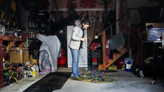 Woman untangling tangled christmas lights.